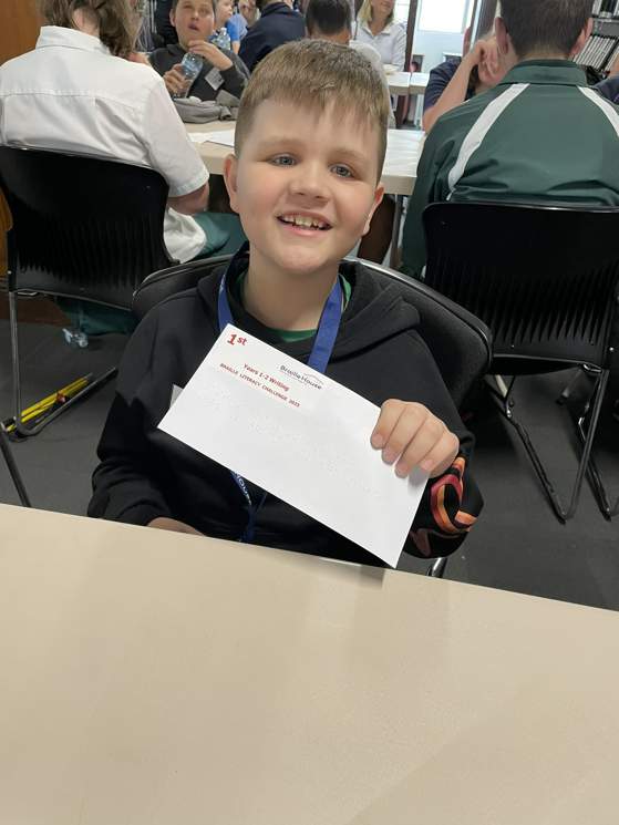 1st place winner for Years 1 to 2 Writing showing off his award