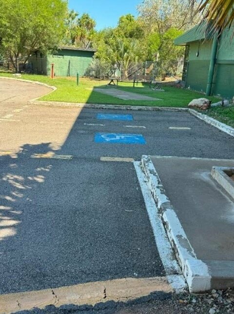 Photograph of No tactile markings to indicate where the roadway starts, with uneven ground right near the disabled parking