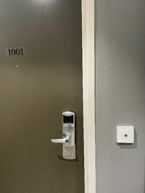 Photograph of guest room door with no Braille indentification